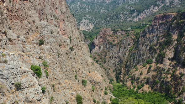 aerial drone panning up through Butterfly Valley overlooking the dry large mountain cliffs of Fethiy