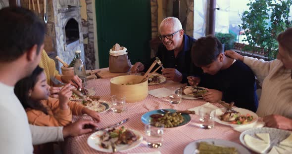 Happy latin family eating dinner at home outdoor