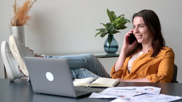 Positive Successful Caucasian Woman Office Worker Creative Manager Sits in a Chair in a Relaxed Pose