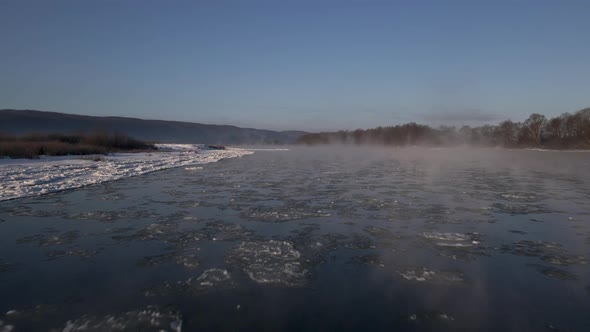 Aerial Drone Close Up View on the Frozen River with Haze and Floating Ice Early Morning