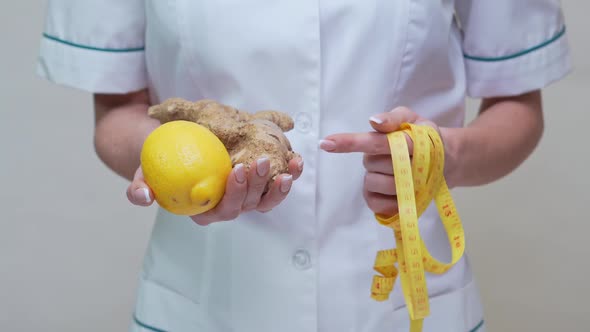 Nutritionist Doctor Healthy Lifestyle Concept - Holding Ginger Root, Lemon Fruit and Measuring Tape