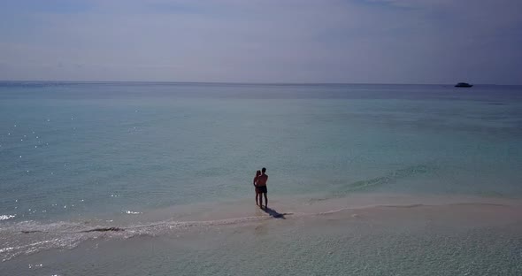 Happy boy and girl on honeymoon vacation have fun on beach on paradise white sand background