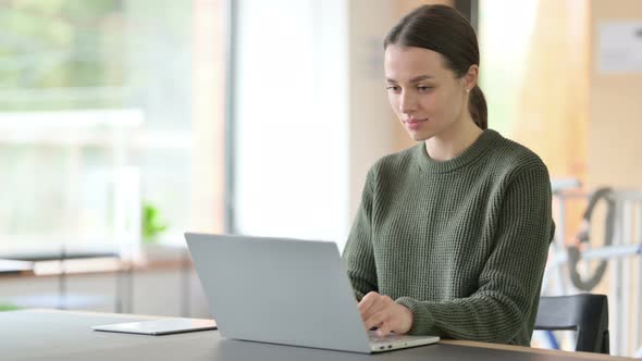 Young Woman Working on Laptop in Office 