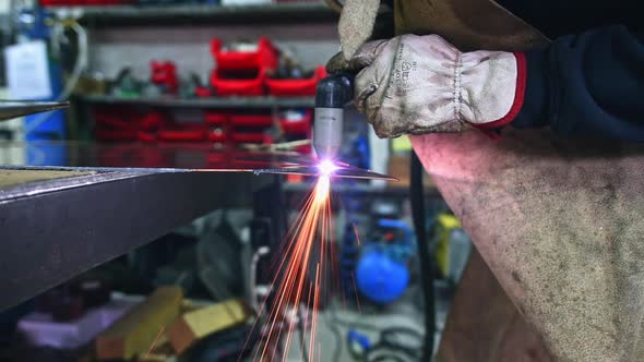 Welder Using Welding Torch in Workshop