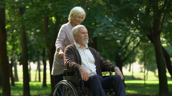 Caring Woman Supporting Her Husband in Wheelchair, Kissing Each Other, Family