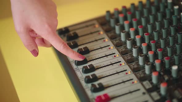 Crop faceless woman moving slider on sound console