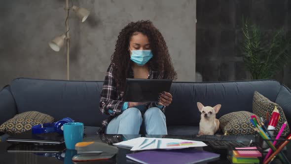 Mixed Race Female in Face Mask Working on Tablet Pc