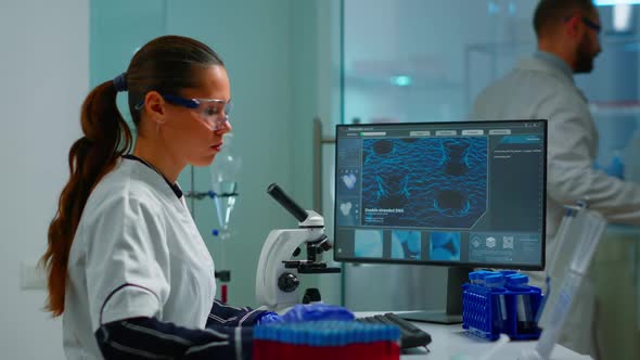 Biotechnology Scientist Researching in Laboratory Using Microscope