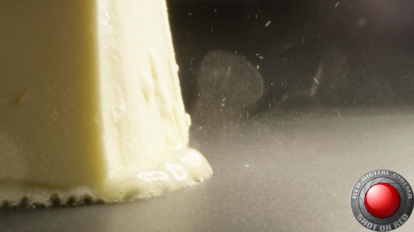 Macro Of Sizzling Butter Slice Melting On A Frying Pan