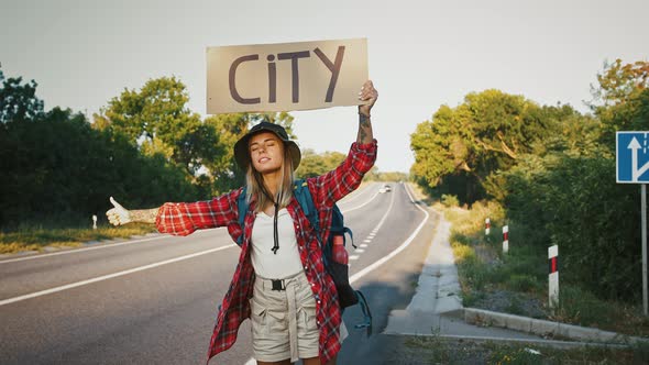 Young Woman Tourist Hitchhiking on Empty Road with Poster City