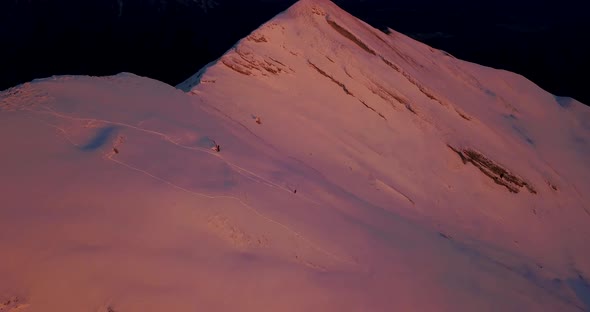 Aerial drone view of snow covered Alps mountains in the winter at sunset.