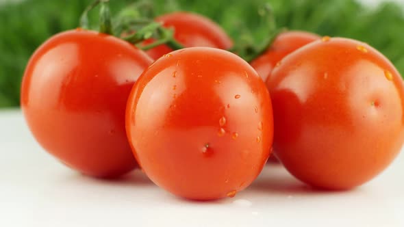 Ripe natural tomatoes close-up. Organic tomato rotating on a green background Macro shot.