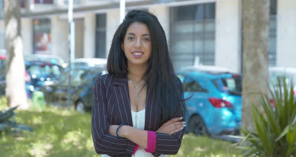 beautiful moroccan businesswoman crosses her arms smiling at camera