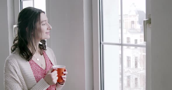 Young woman at home enjoying a cup of coffee