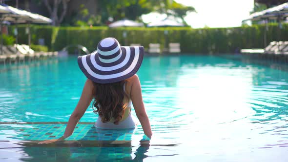 Young asian woman enjoy around outdoor swimming pool for leisure