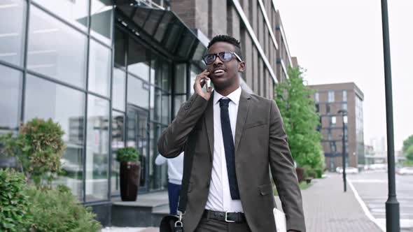African Businessman Walking and Talking on Phone