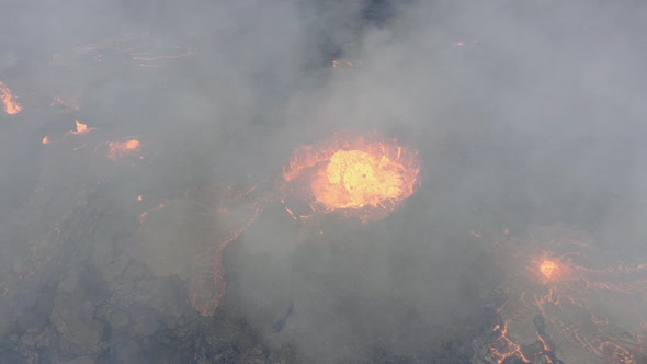 Drone engulfed in smoke over active, hot and continuous volcanic eruption with fresh flowing lava. A