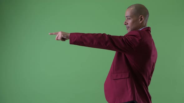 Profile View of Happy Bald Multi Ethnic Businessman Pointing Finger