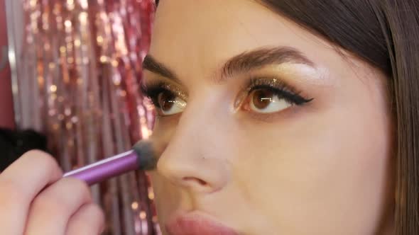 Brush Applies Foundation to the Face of a Beautiful Young Model for Evening Makeup Smoky Eyes