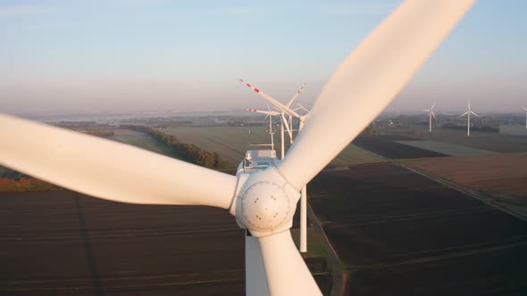 Aerial View of a Wind Turbine Farm During Sunrise with Fog