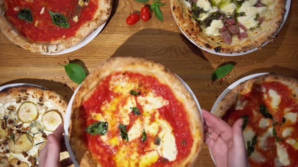 Serving Traditional Italian Pizza with Basil Cheese and Tomato Sauce on the Wooden Table