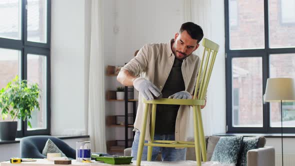 Man with Sponge Sanding Old Wooden Chair at Home