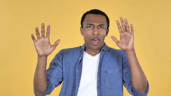 Young African Man Confused and Scared of Problems Yellow Background