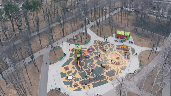 Children's Playground with Playing Children in the Spring Park at the End of the Quarantine