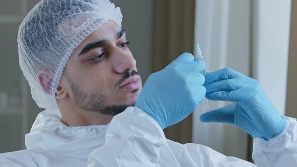 Portrait of Young Arabic Hispanic Male Doctor Nurse in Medical Cap and Latex Gloves Holding Syringe