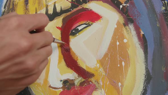 Close Up Of A Hand Holding Paintbrush Mixed Colour And Painting A Girl's Nose On The Canvas