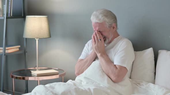 Upset Old Man Sitting in Bed Crying