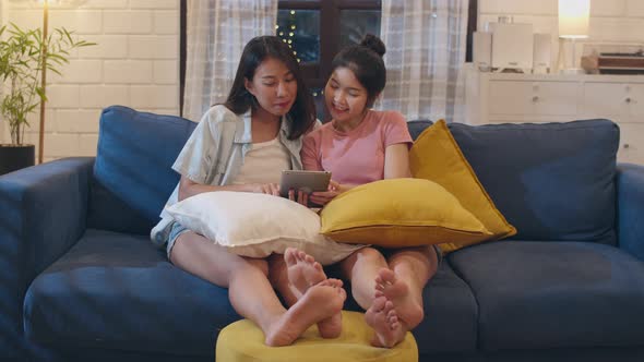 Lesbian lgbt women couple using tablet at home in night.