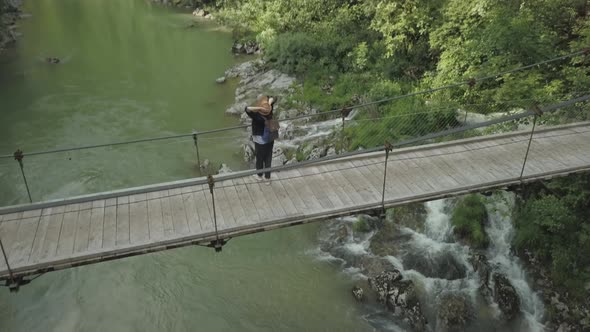 Aerial view of woman traveler walking on the bridge under Tara river in Montenegro