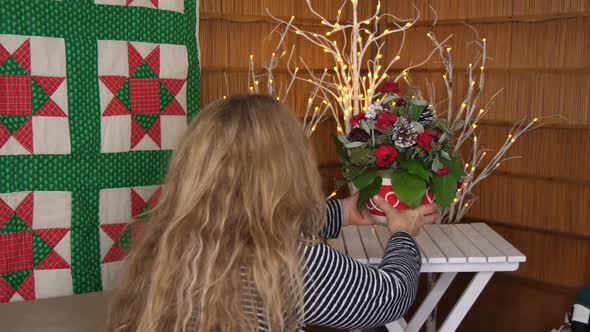 Woman putting Christmas Pot decorations on table in Home, Static Locked Off