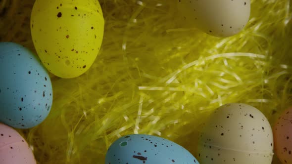 Rotating shot of Easter decorations and candy in colorful Easter grass 