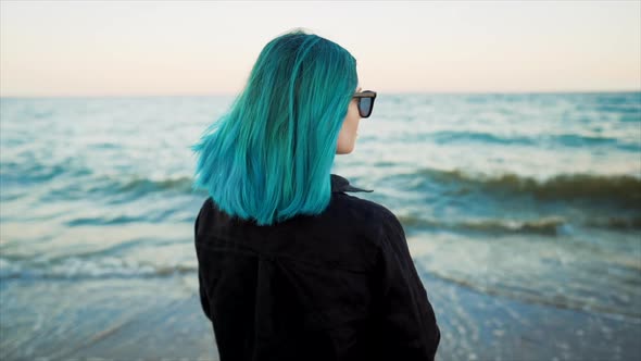 Unrecognizable Woman with Blue Dyed Hair Standing on Sea Beach Background. Portrait of Trendy Girl