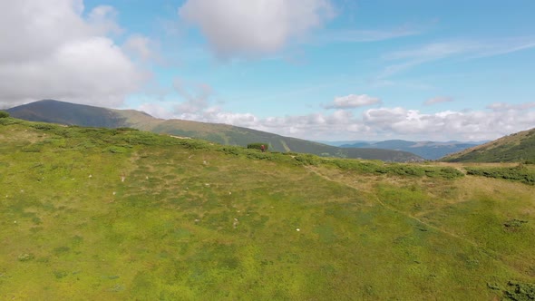 Aerial View of a Traveler with Backpack Climbing Along Mountain Slope. Epic Shot