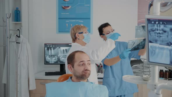 Senior Dentist and Nurse Analyzing x Ray Scan to Find Diagnosis