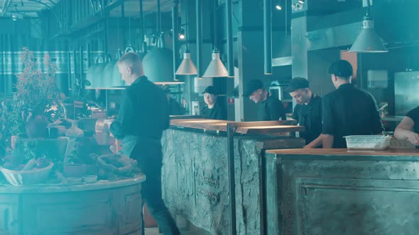 Open Kitchen of a Restaurant with Personnel in Uniforms