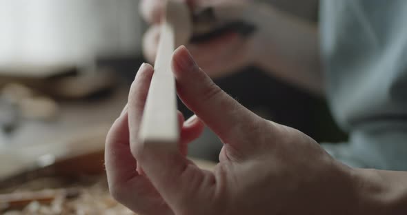 Young Woman Carpenter Examines Handmade Wooden Spoon Extreme Close-up