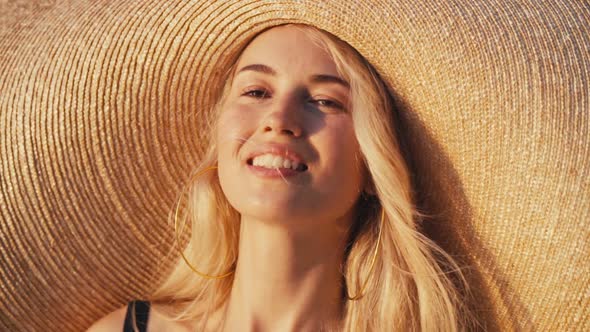 Beautiful Girl Wearing Big Straw Summer Hat on the Beach