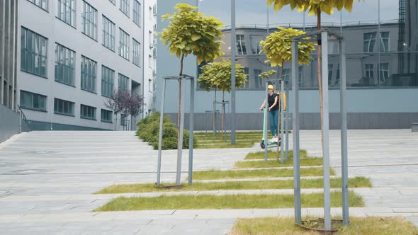 Delivery Woman with Thermo Bag or Backpack Riding an Electric Scooter Along the