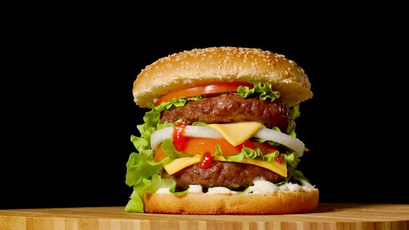 Great Burger with Beef Cutlet, Tomatoes, Mushrooms and Cucumbers with Melted Cheese Rotates on a