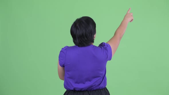 Rear View of Young Overweight Asian Woman Pointing Finger