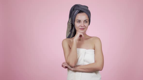 Woman with Towel on Head Looking at Camera, Smiling, Isolated on Pink Background