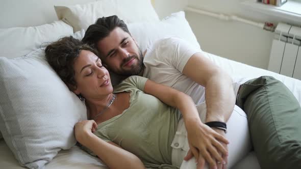 Young Married Couple is Having Good Time Together Lying on Bed in Apartment Spbd