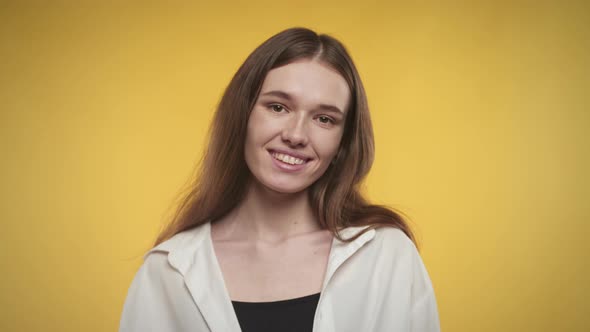 Young Adult Caucasian Woman is Laughing on a Bright Yellow Background