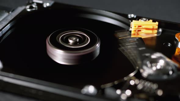 Opened Hard Disk Drive with Spinning Platter. Move of Writing Magnetic Head