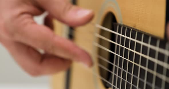 Closeup of Male Musicians and Playing the Strings of an Acoustic Guitar