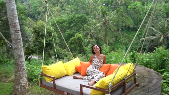 Happy Woman Enjoying Cosy Flying Bed Swing in the Rainforest Pure Happiness on Tropical Summer